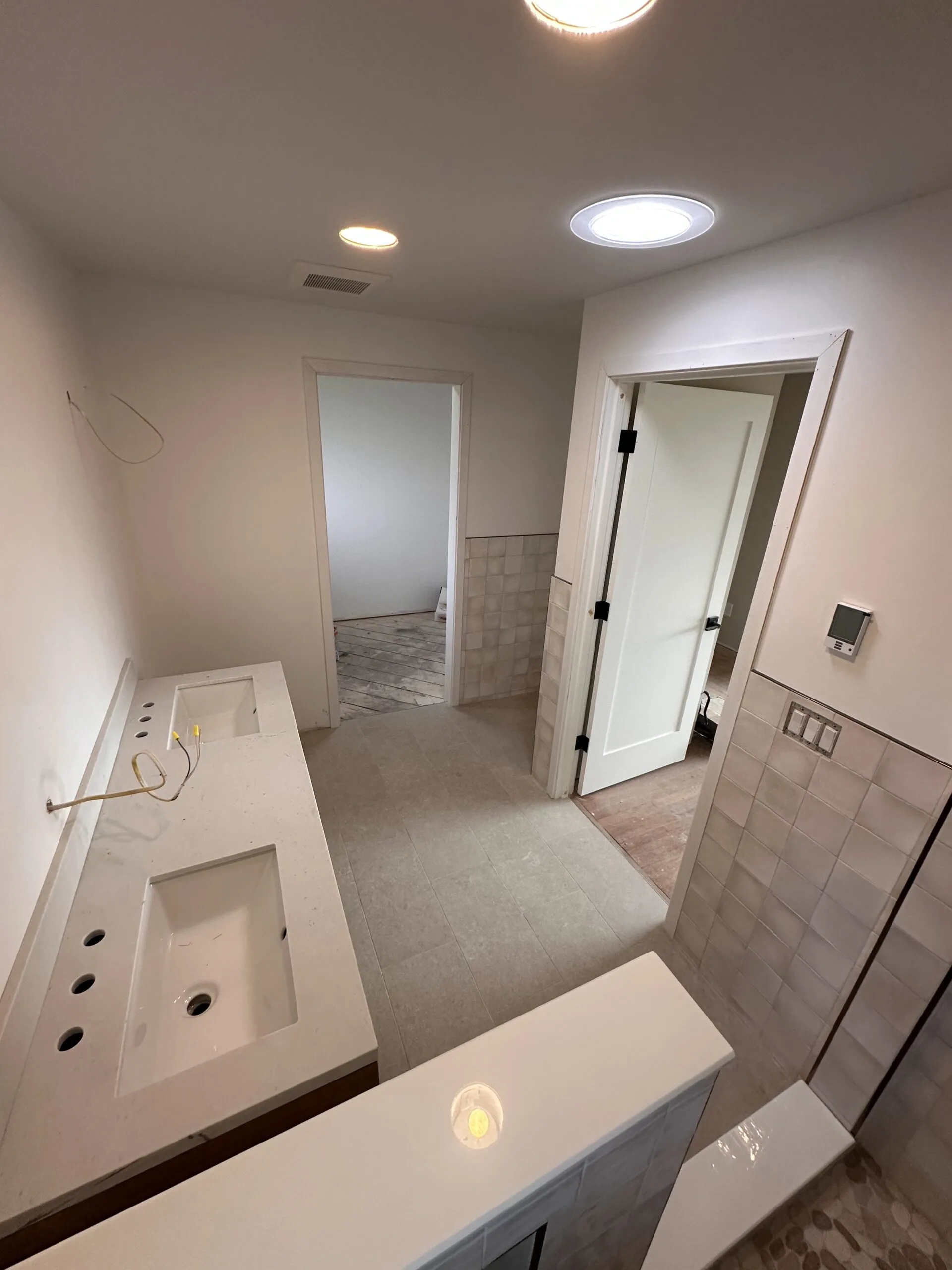 Double vanity bathroom — large format tile, frameless glass, recessed lighting