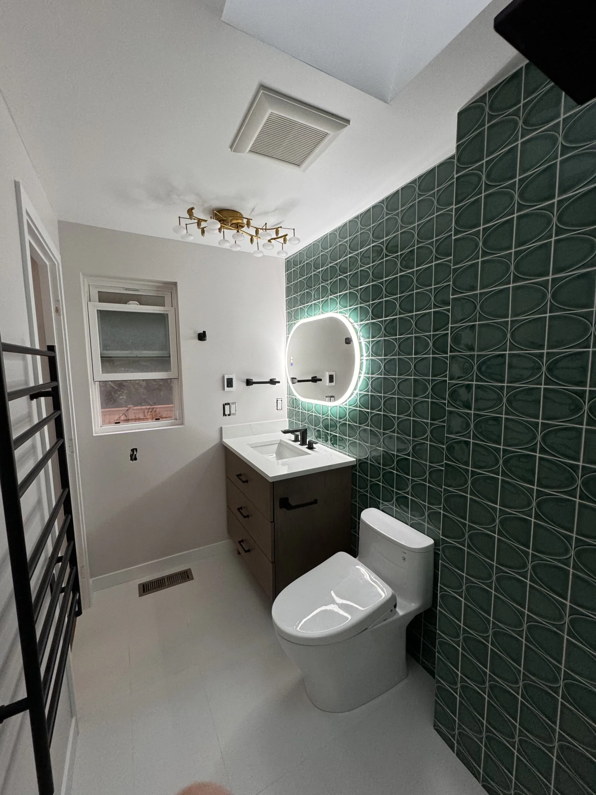 Guest bathroom — emerald zellige tile, LED mirror, matte black fixtures